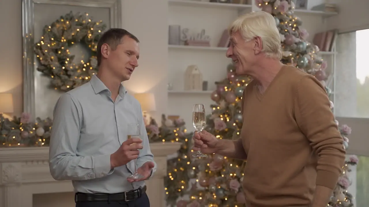 Old And Young Man Have A Glass Of Champagne And Talk