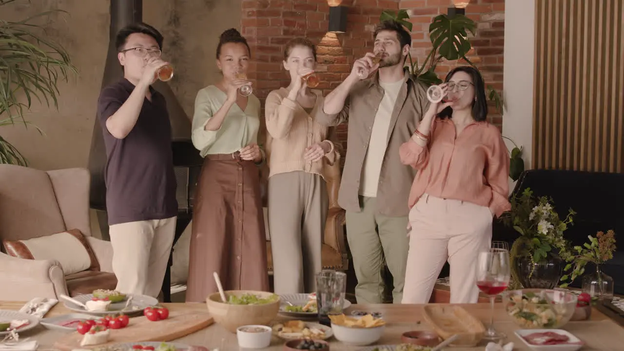 A Multiethnic Group Of Friends Toast With Their Glasses At A Dinner Party