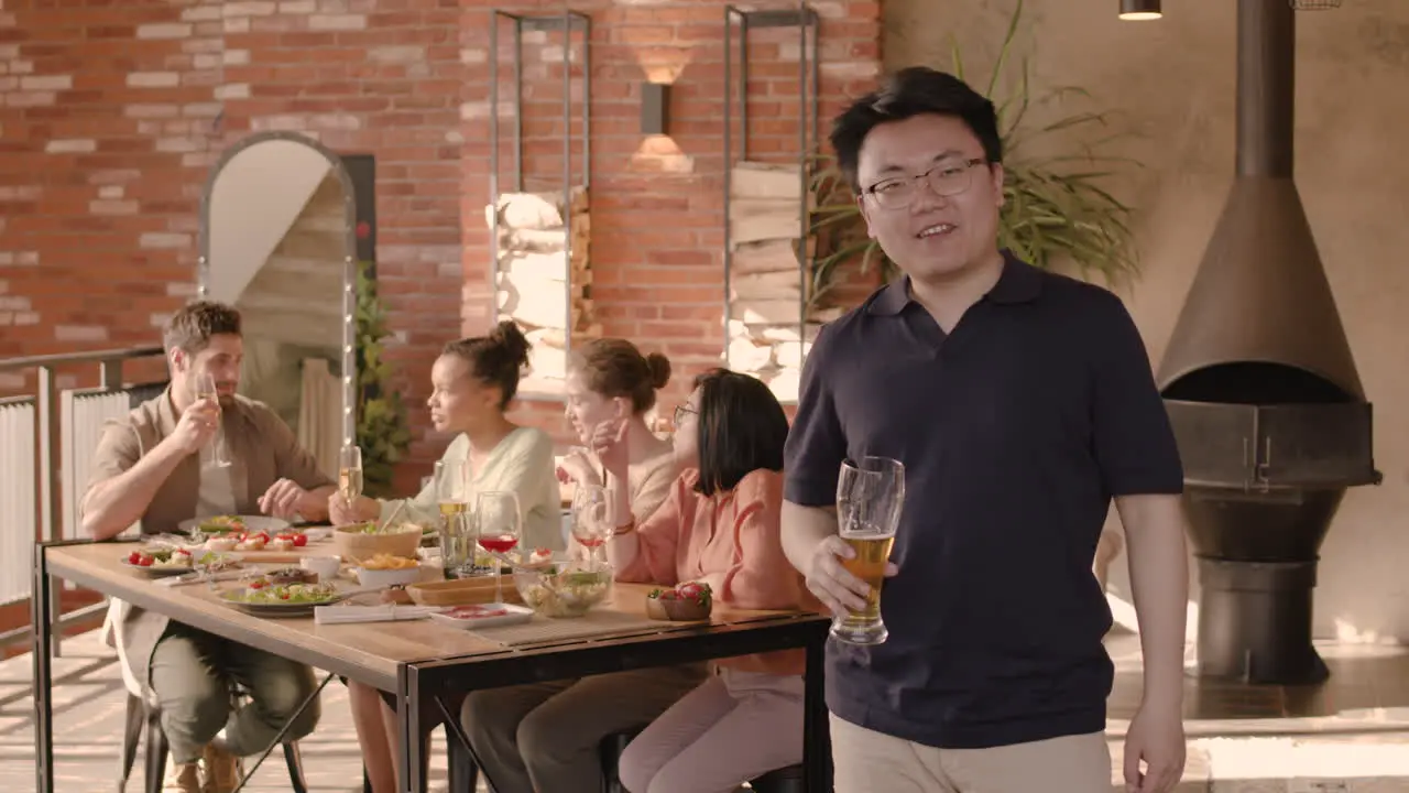 An Young Man Drinking Beer At A Dinner Party