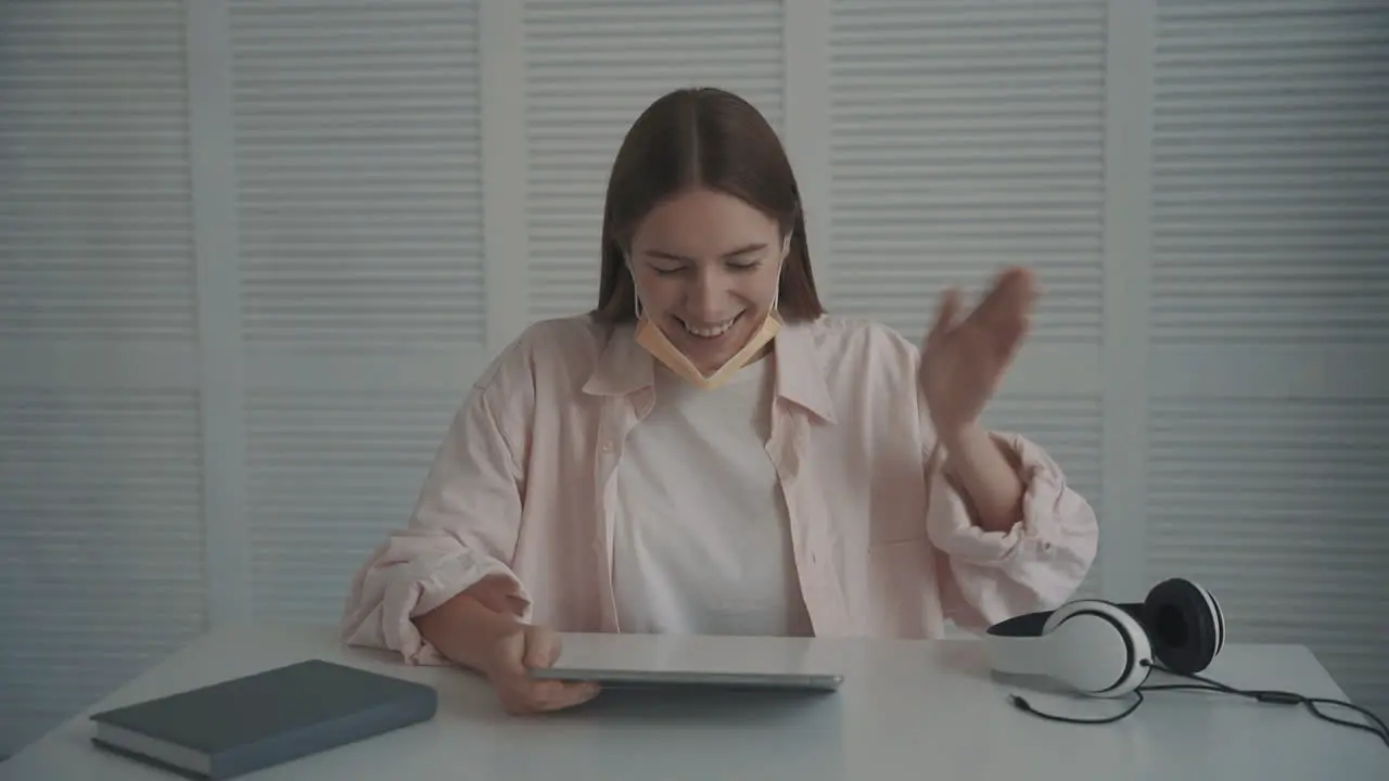 Young Woman With Face Mask Holding A Tablet Has A Video Call