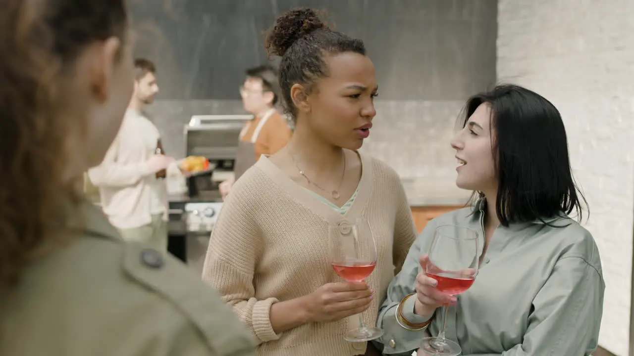 A Nice Multicultural Group Of Three Girls Chatting Happily And Drinking Wine At A Barbecue On The Terrace Of A House 1