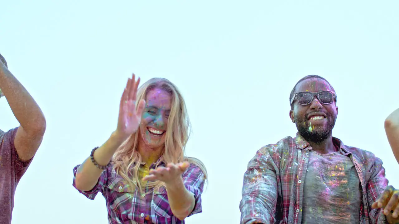 Beautiful Cute Two Blond Girls And Stylish Guy In Dark Glasses Tossing Colorful Paints In Powder Up In The Air And Having Fun At The Holi Celebration