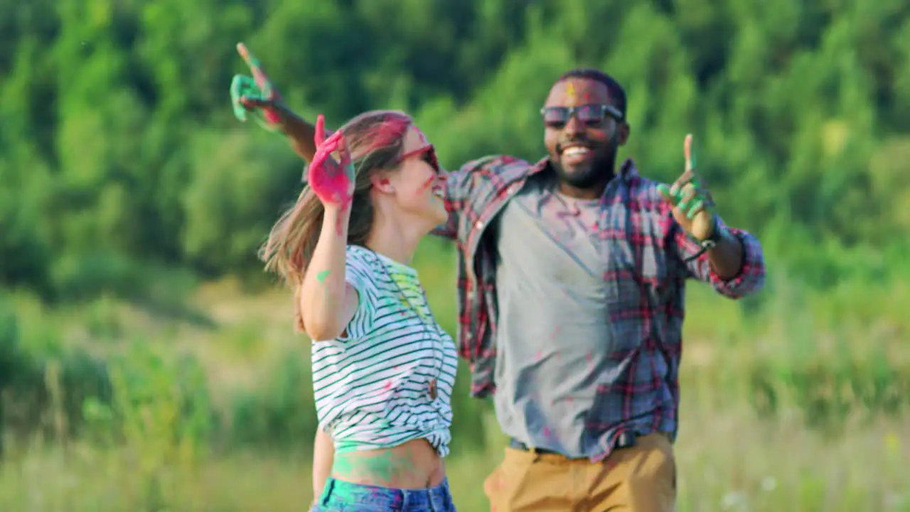 Young Handsome And Joyful Guy Dancing And Having Fun With Pretty Girl At The Holi Festival Outside