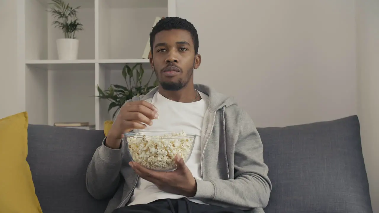 Young Man Watching Attentively A Movie And Eating Popcorn 1