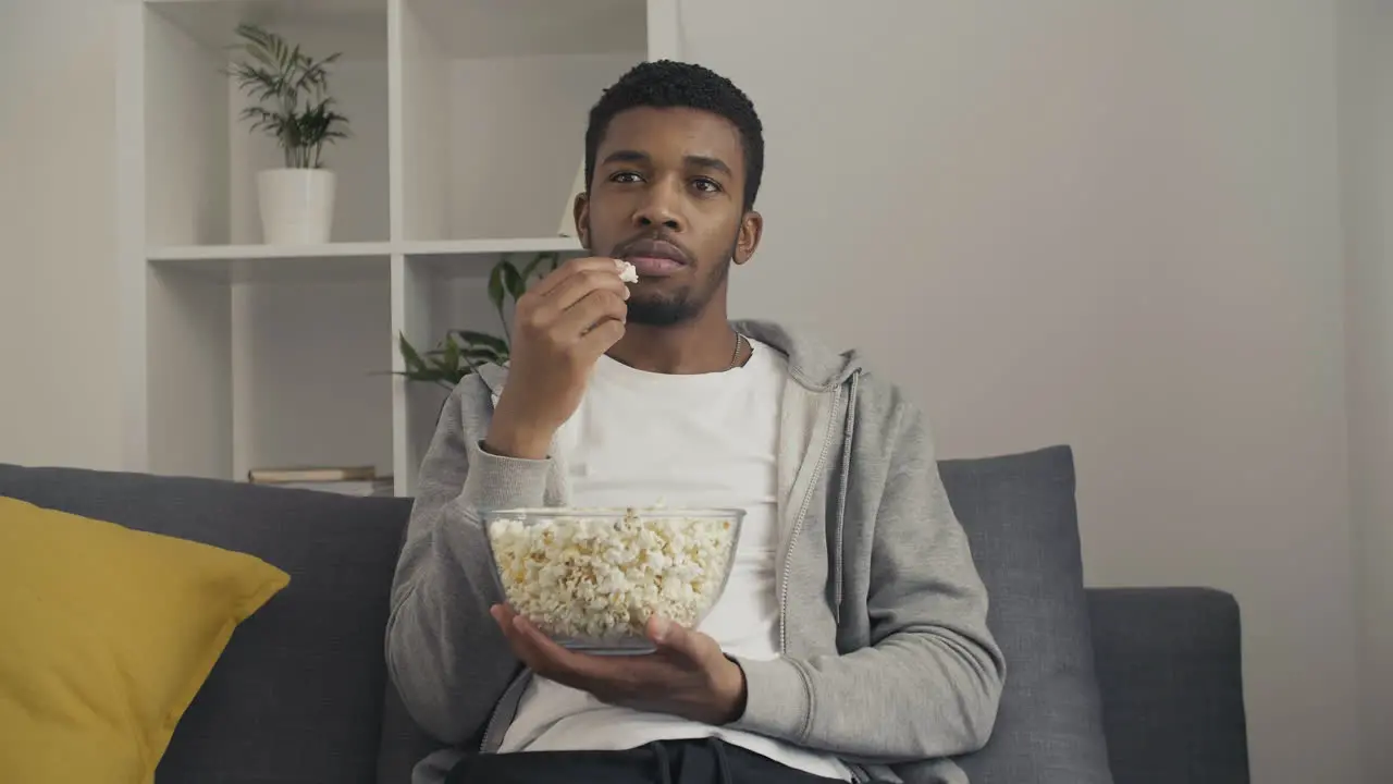 Young Male Watching Attentively A Movie And Eating Popcorn