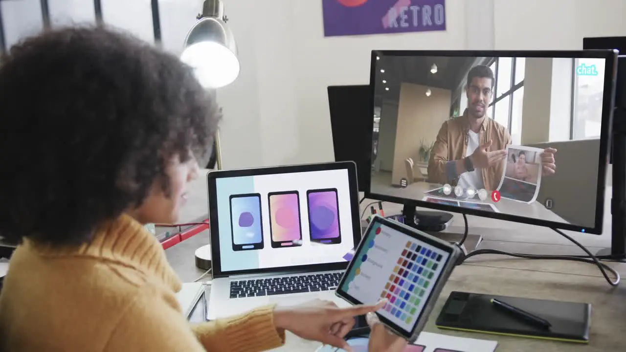 African american businesswoman on video call with african american male colleague on screen