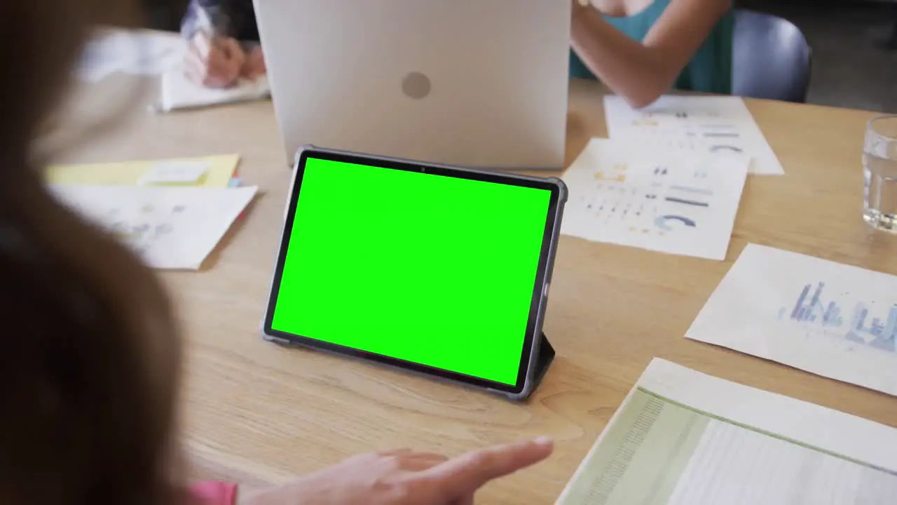 Caucasian businesswoman on tablet video call with green screen