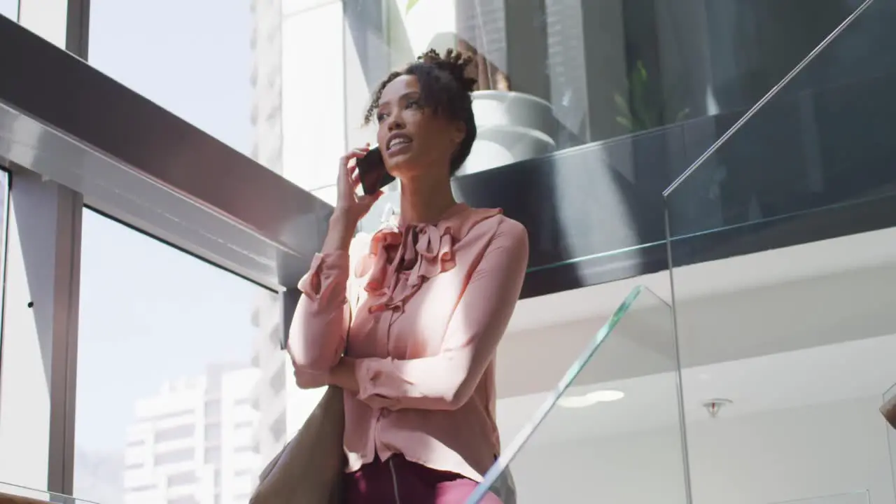 African american businesswoman talking on smartphone in creative office