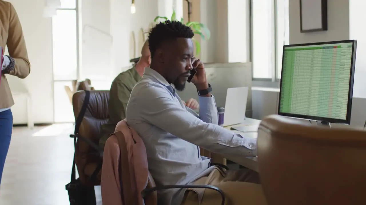 African american businessman talking on smartphone in creative office