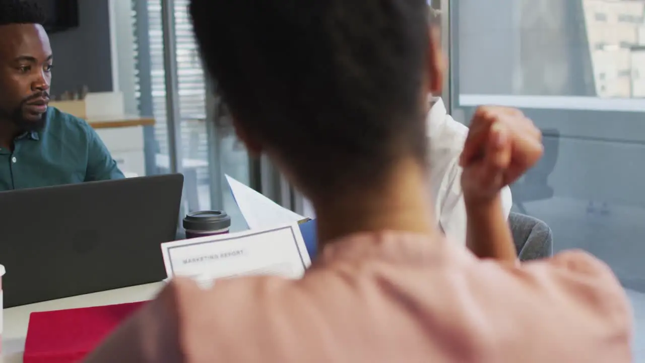 Diverse business people discussing with documents in creative office