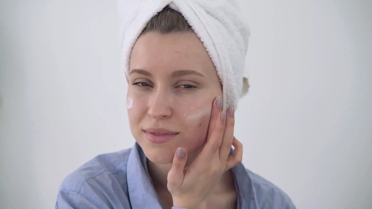 Portrait Of Young Woman Applying Moisturizer