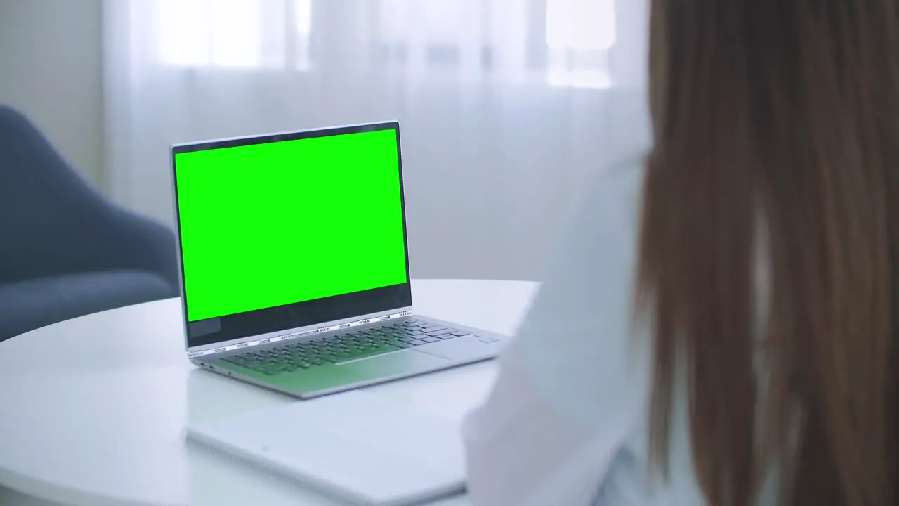 Woman doctor is consulting online laptop with green screen on table chroma key concept