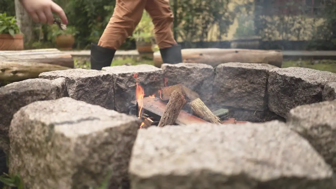 Feeding the campfire flame with leaves