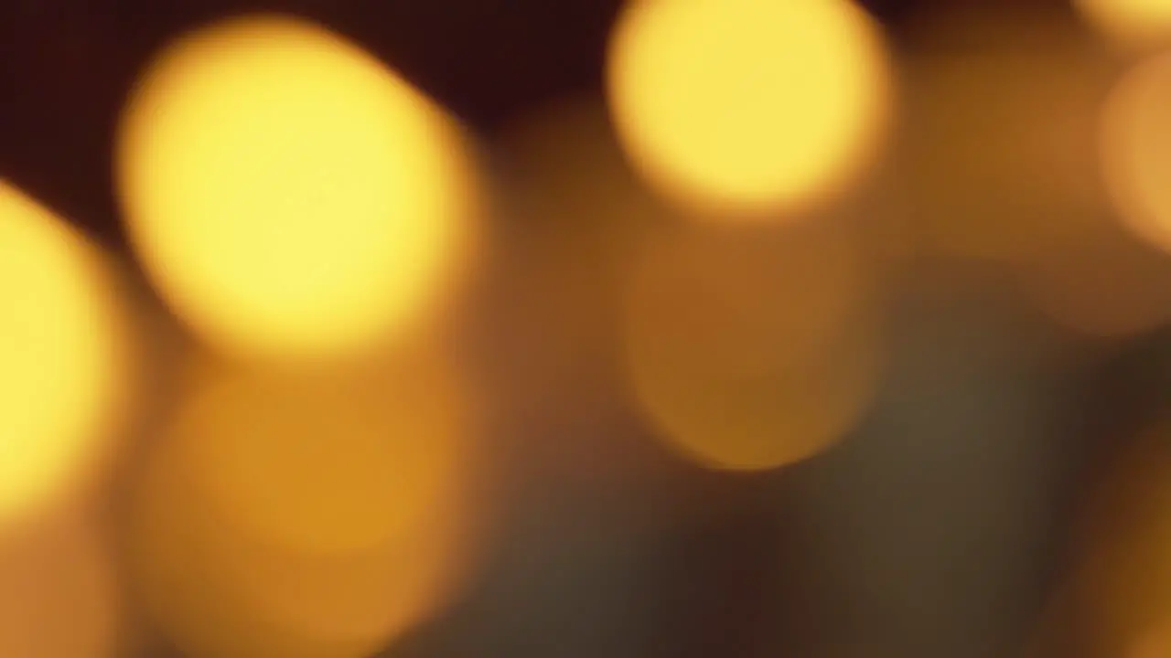 Defocused bokeh from candle flames glowing and shimmering in the gentle breeze