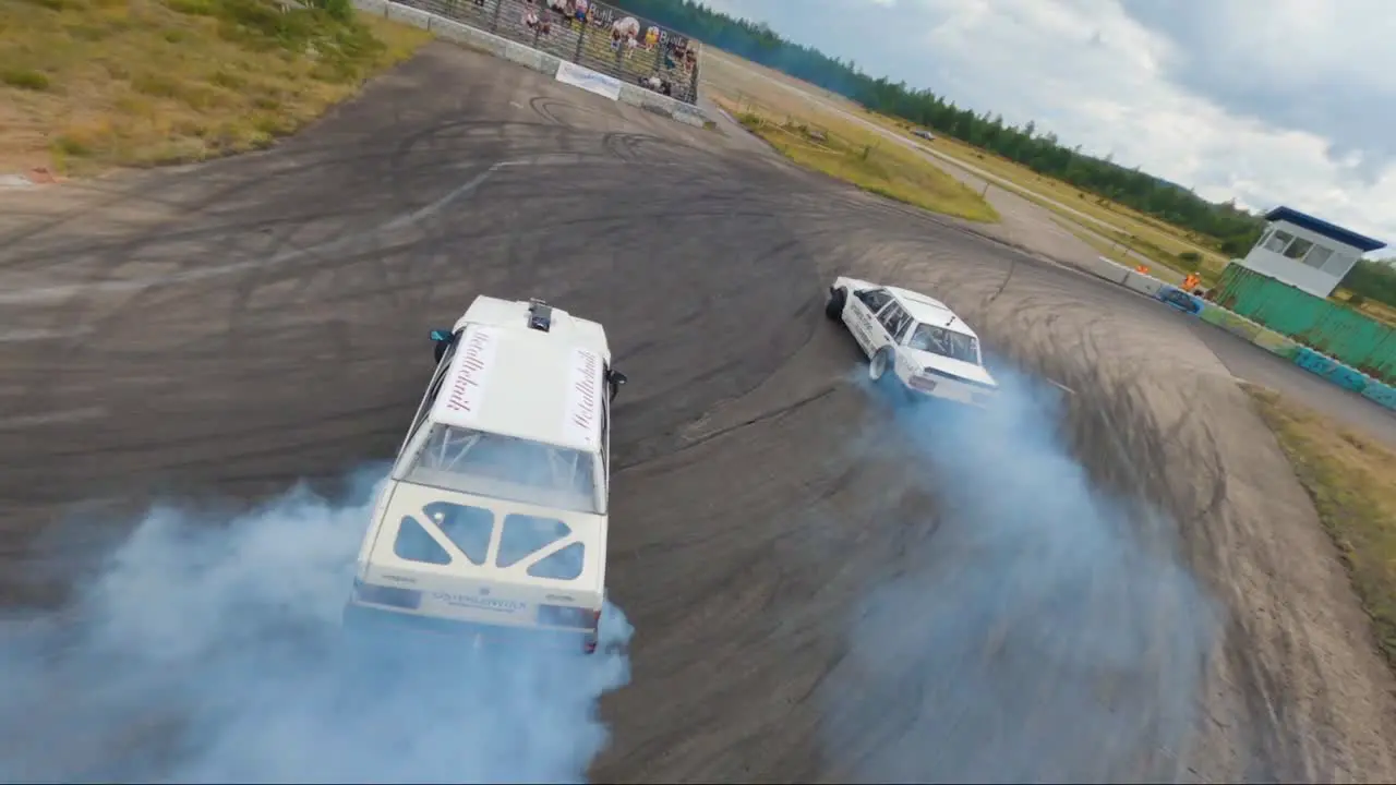 Two Volvo 740 cars drifting together in Hultsfred Drift Track filmed with FPV drone