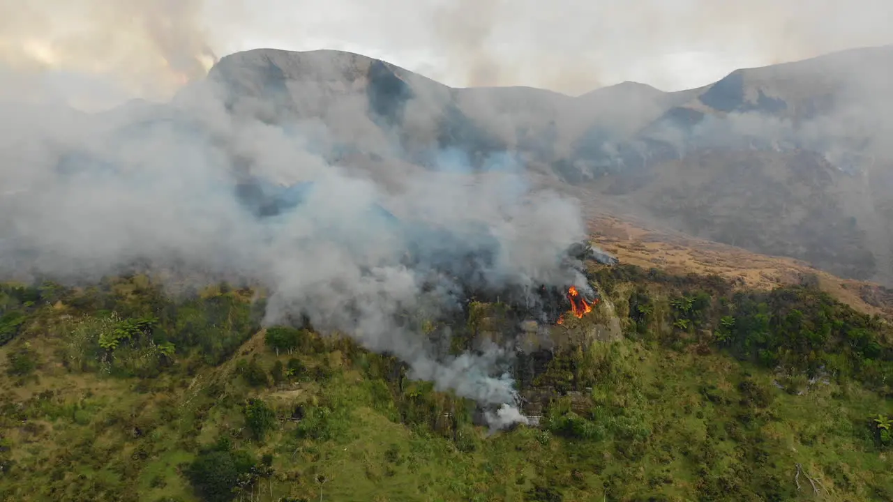 Aerial view of smoke rising into the sky as a wildfire burns on a mountainside