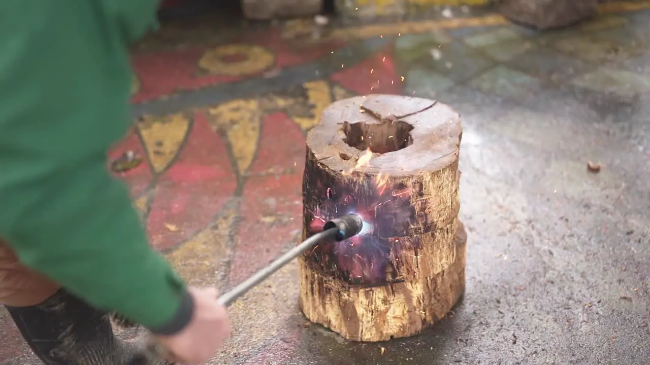 Craftsman burn with a blow torch a tree log