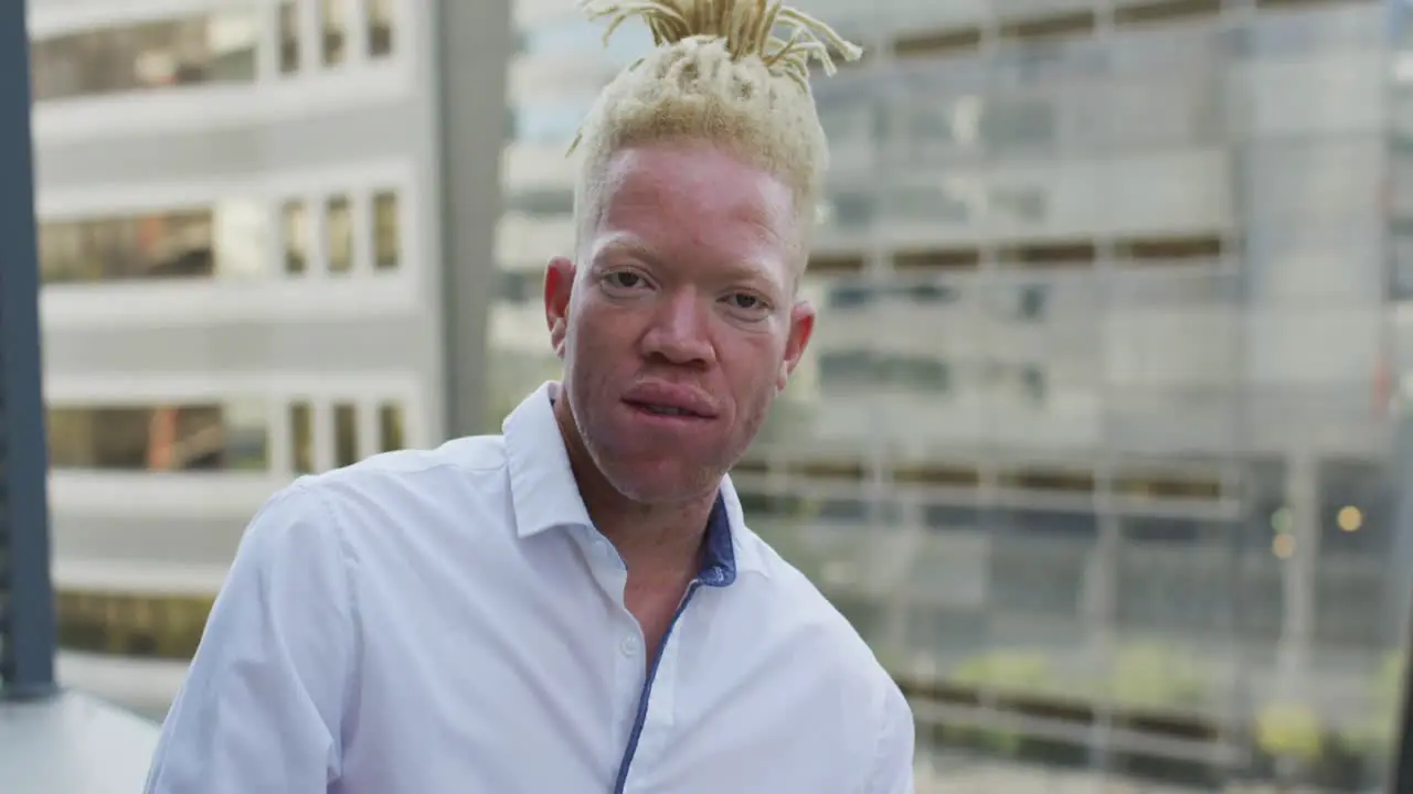 Portrait of happy albino african american businessman in creative office