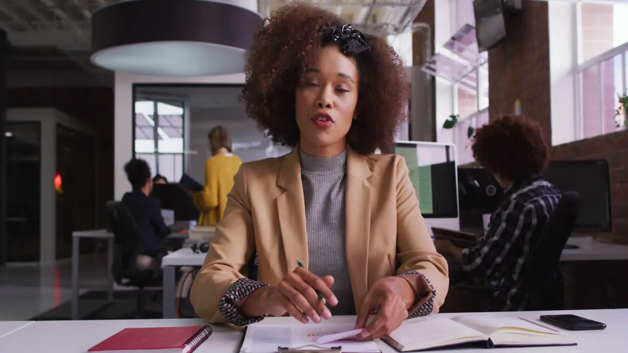 Happy mixed race businesswoman having video call sitting in front of computer