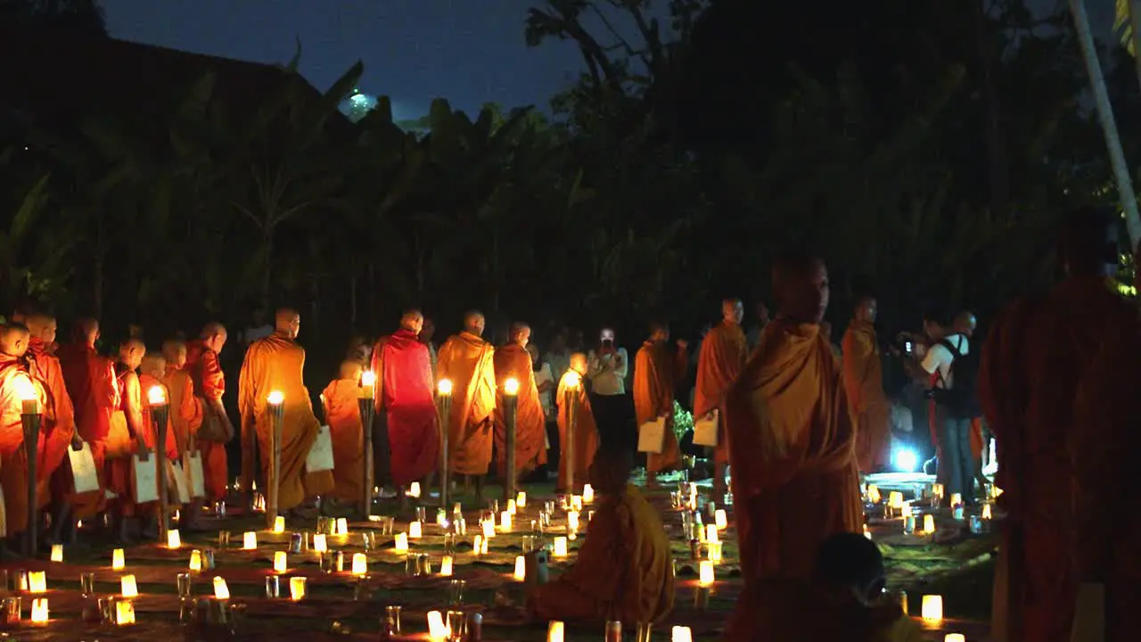 Medium Exterior Shot of Lots of Monks Walking in Row With Many Candle Lights