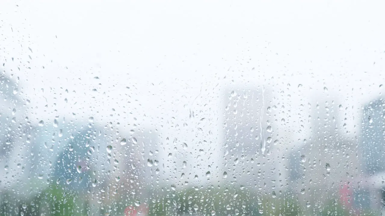 City window with rain and water on glass