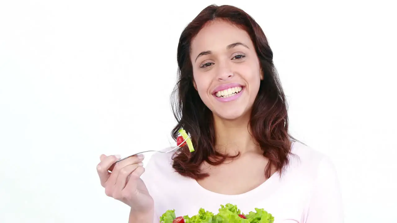 Pretty smiling woman eating salad