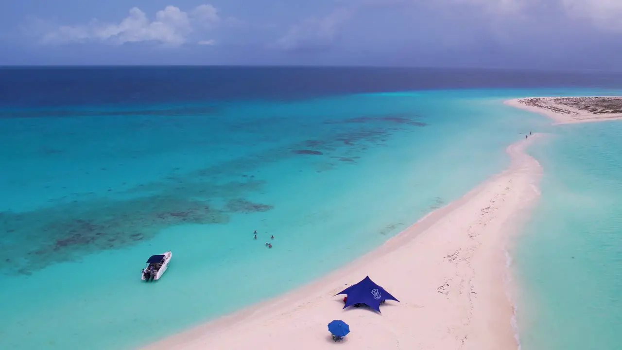 Aerial turn around sandbar on tropical island with people bath cayo de agua Los Roques