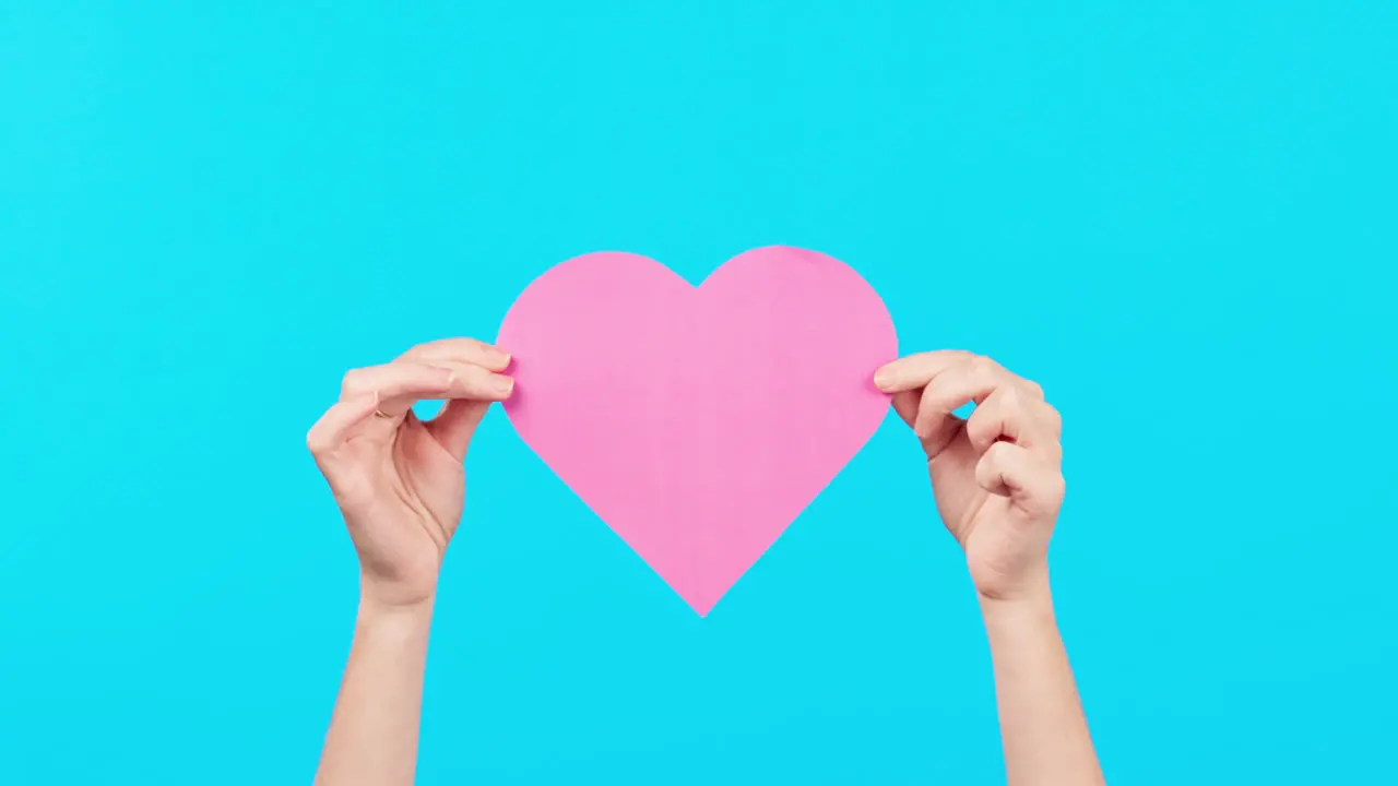 Blue background space and hands with a heart card