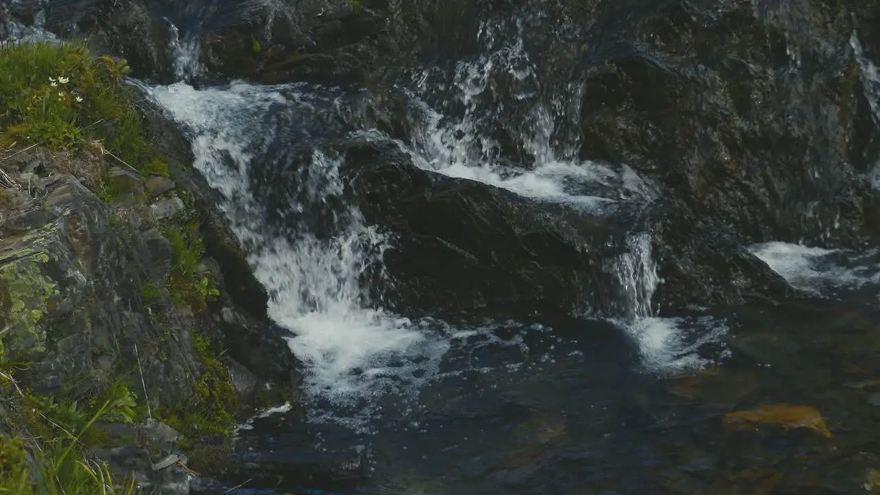 A scenic shot of water flowing over rocks in the mountains of Alberta in Canada