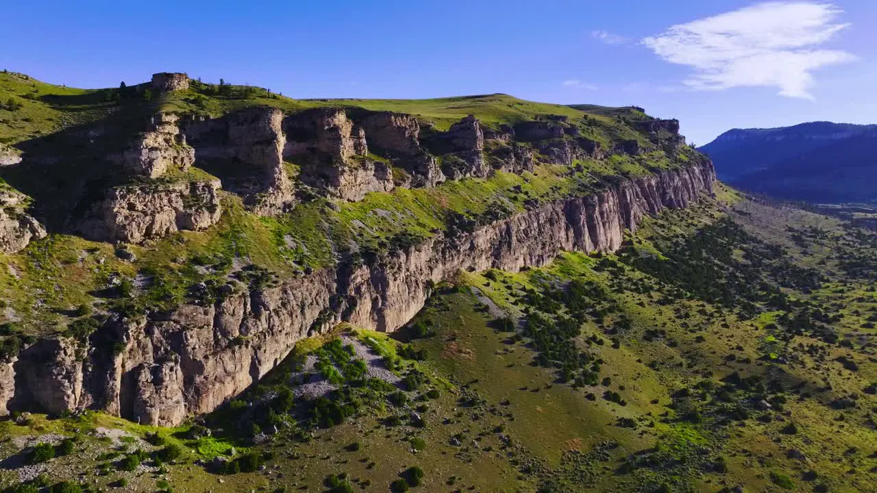 Aerial view of a beautiful mountain range with blue skies and green foliage in Wyoming during the summer