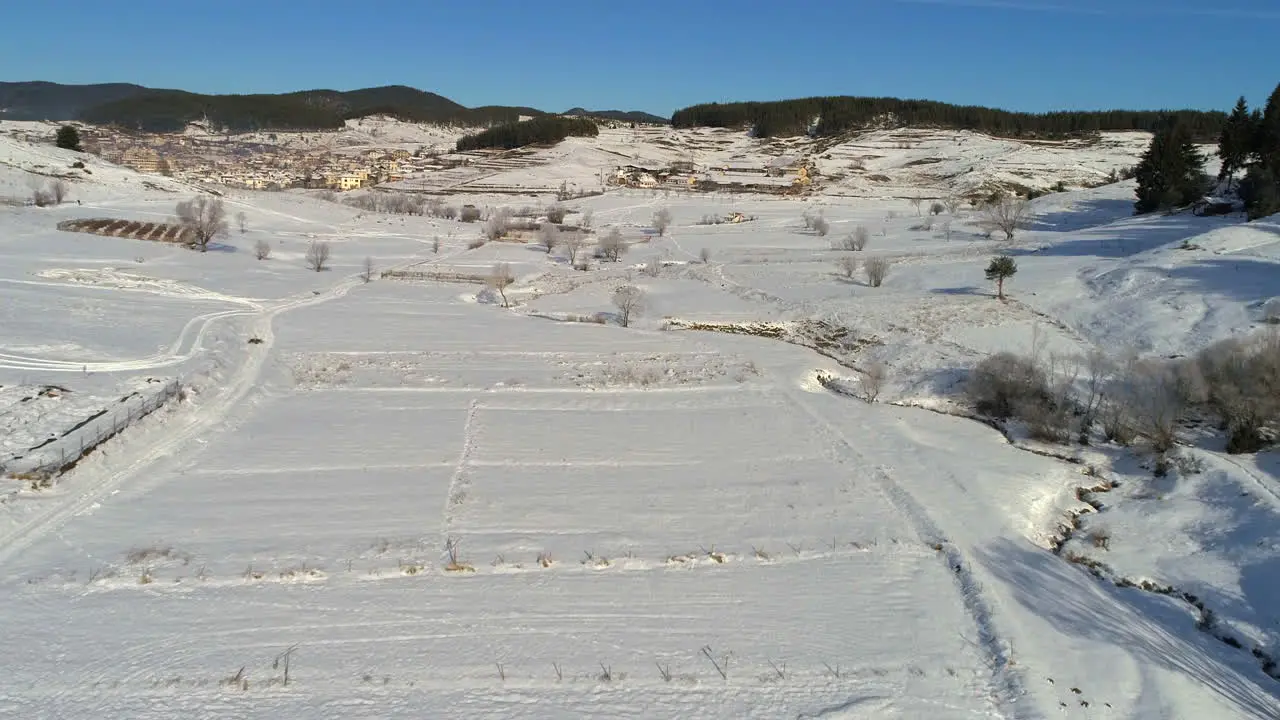 AERIAL Flying above arable land covered with snow everything is white