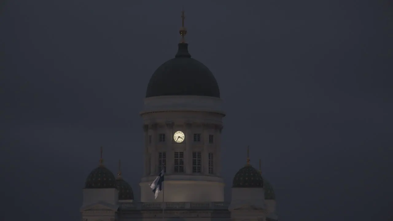 Night view of the Helsinki Cathedral and waving Finnish flag in front