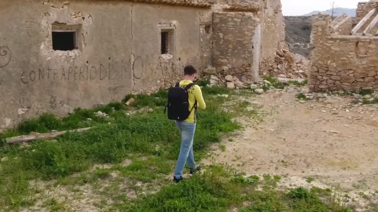 Young man exploring old ruins and taking photo in slow motion