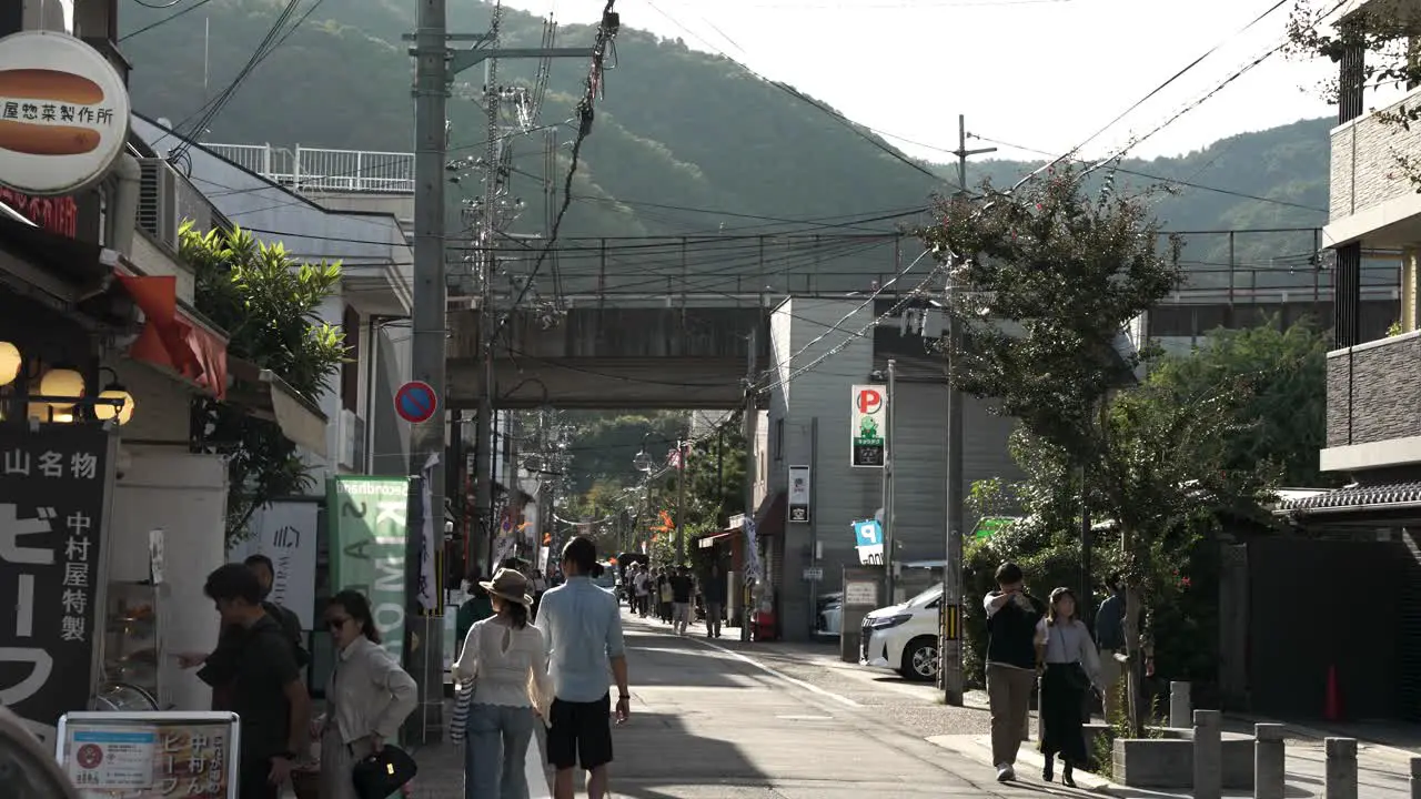 Sunny Afternoon View Of Road Leading To Arashiyama Bamboo Forest With People Walking Along