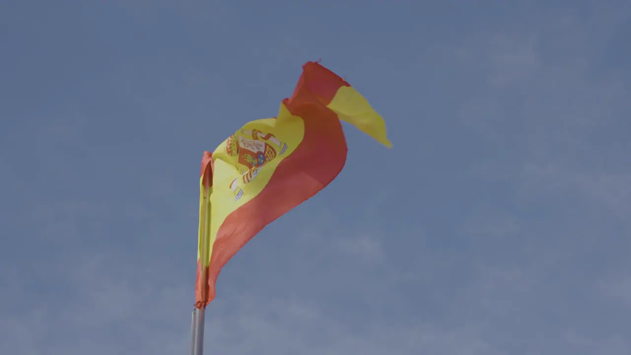 Spanish national flag waving in slow motion on sunny day