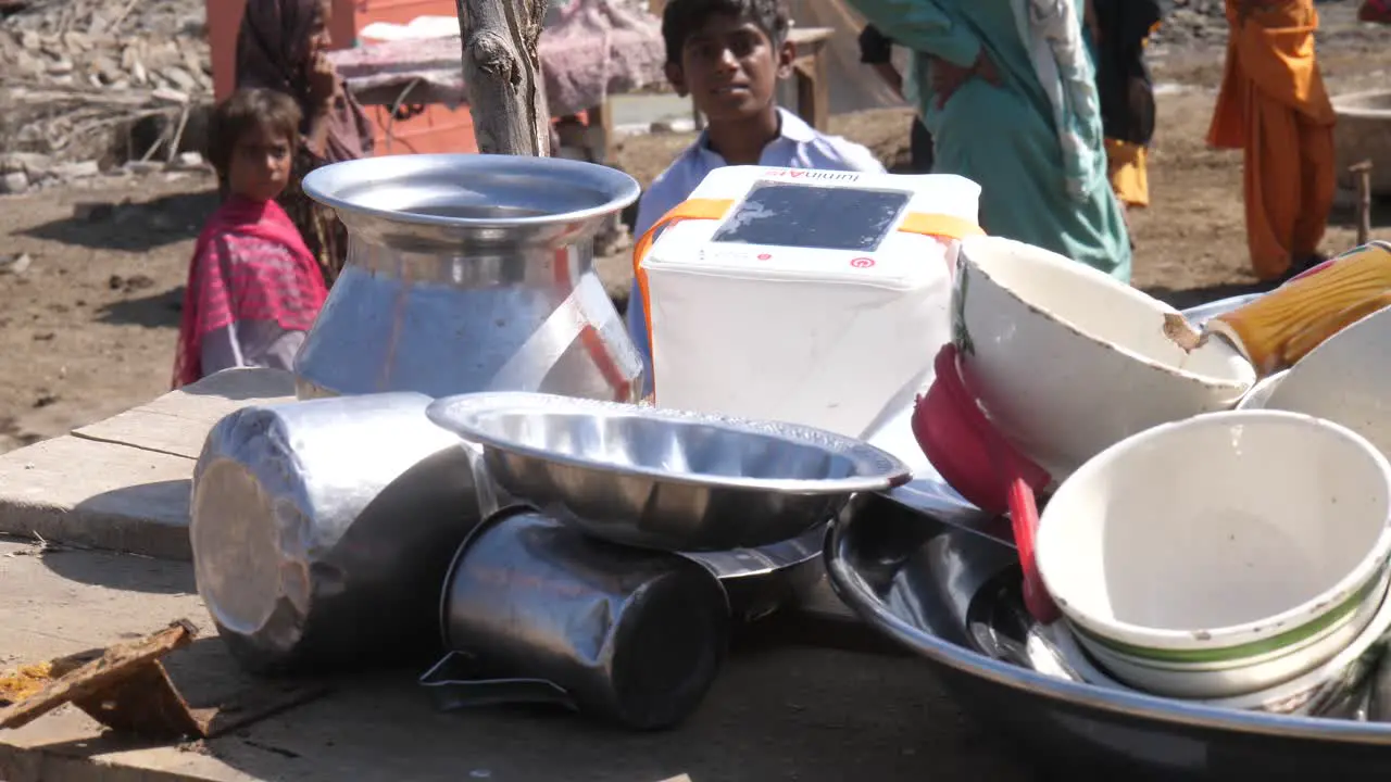 Pile Of Metal Bowls Drinking Cups On Table Outside In Camp For Flood Victims In Sindh