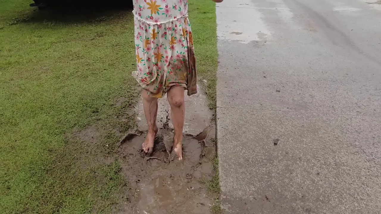 Unrecognizable Young Little Girl With Dress Jumping in Mud Puddle Slow Motion