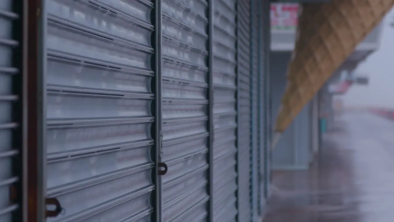 Shutters down at an American Pier in a rain storm wet grey day