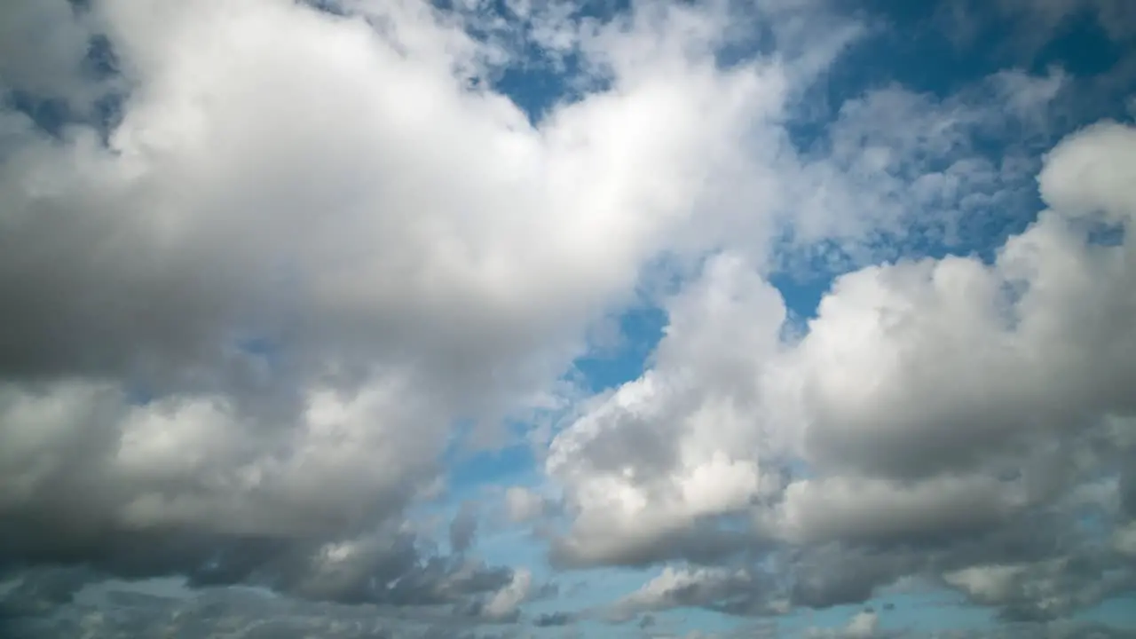 Timelapse of clouds moving towards the viewer in a blue sky