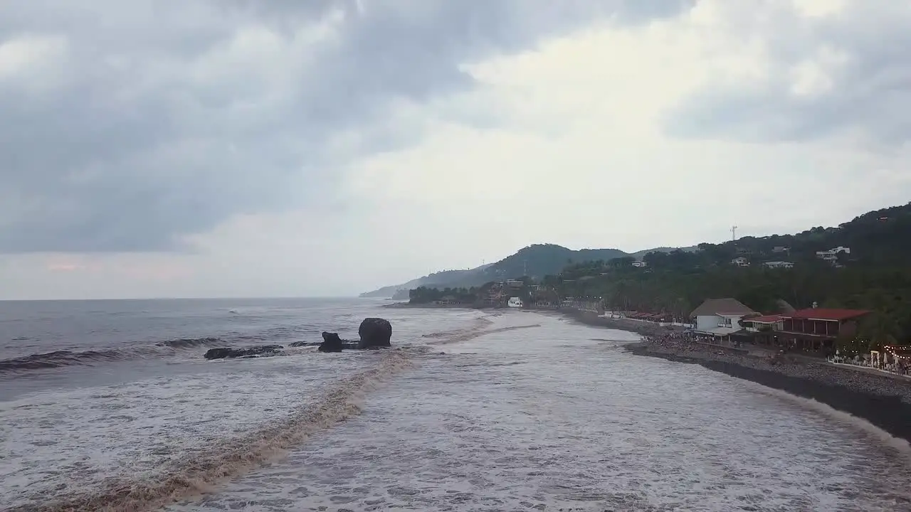 Popular surf spot El Tunco beach in El Salvador during an overcast and cloudy day Aerial footage Dolly in-1