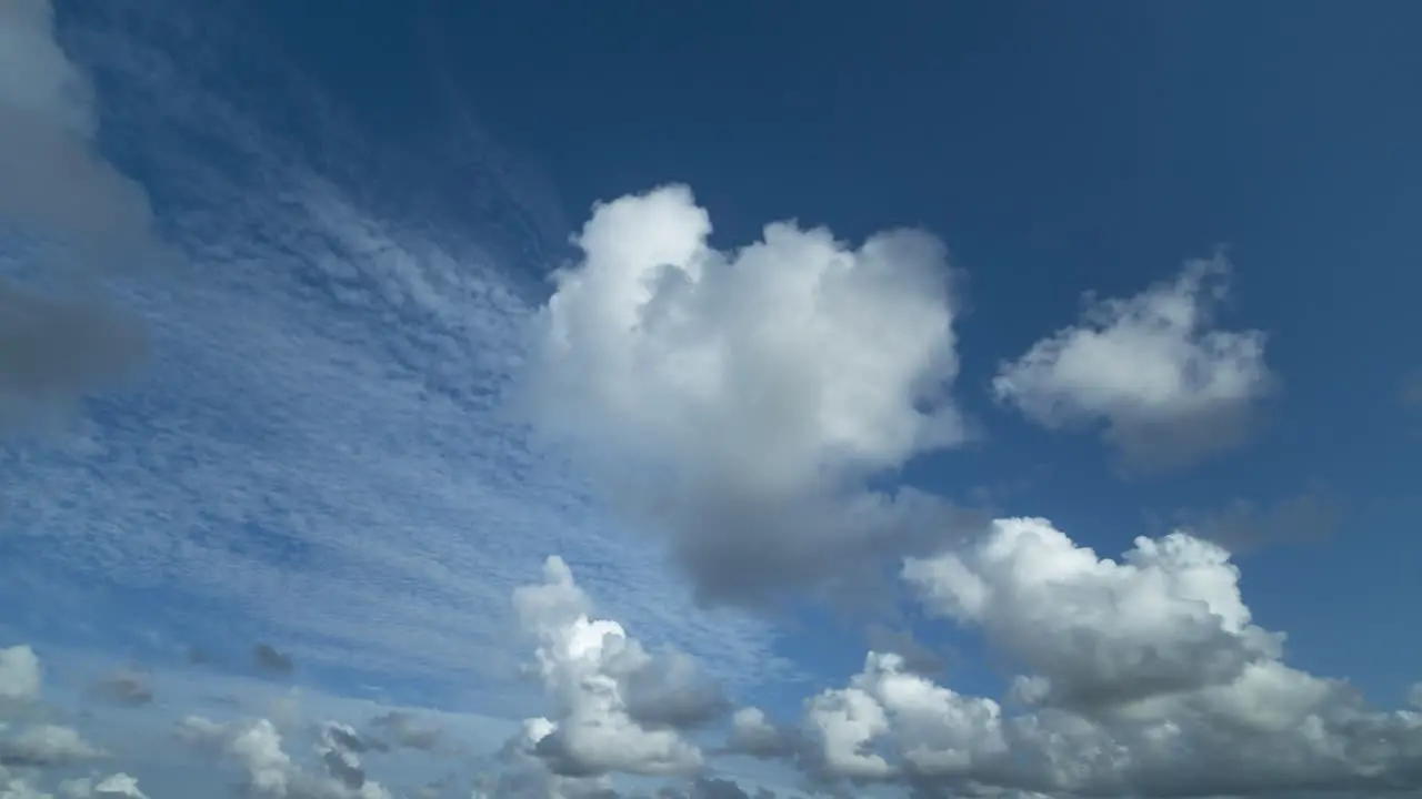 Timelapse of clouds moving sideways in a blue sky 