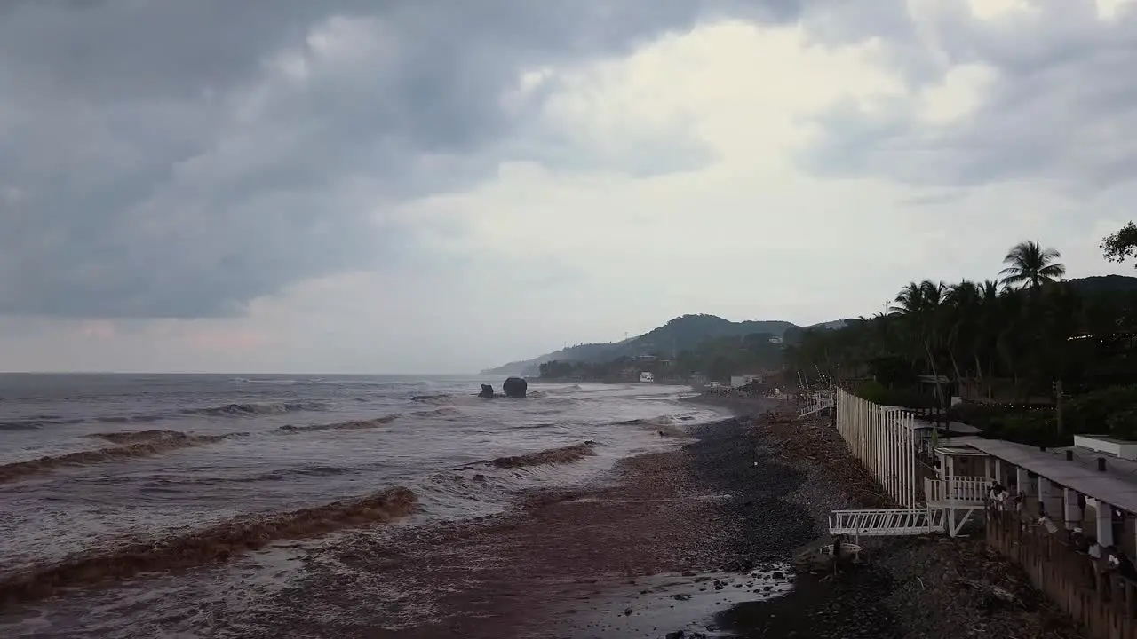 The boardwalk at the popular surf spot El Tunco beach in El Salvador during an overcast and cloudy day Aerial footage Dolly in