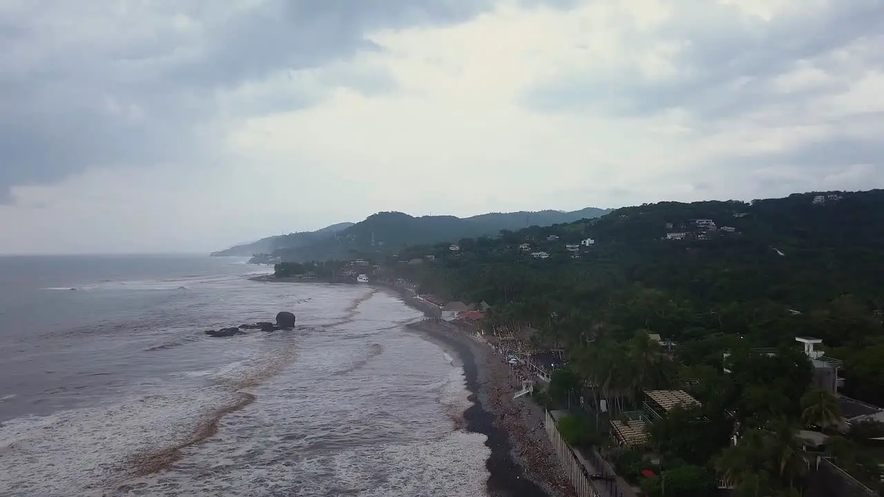 Popular surf spot El Tunco beach in El Salvador during an overcast and cloudy day Aerial footage Dolly in