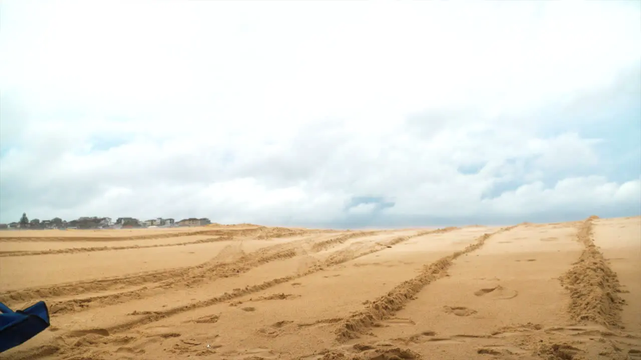 A blue chair flies through the air at the beach in slow motion as if blown by the wind