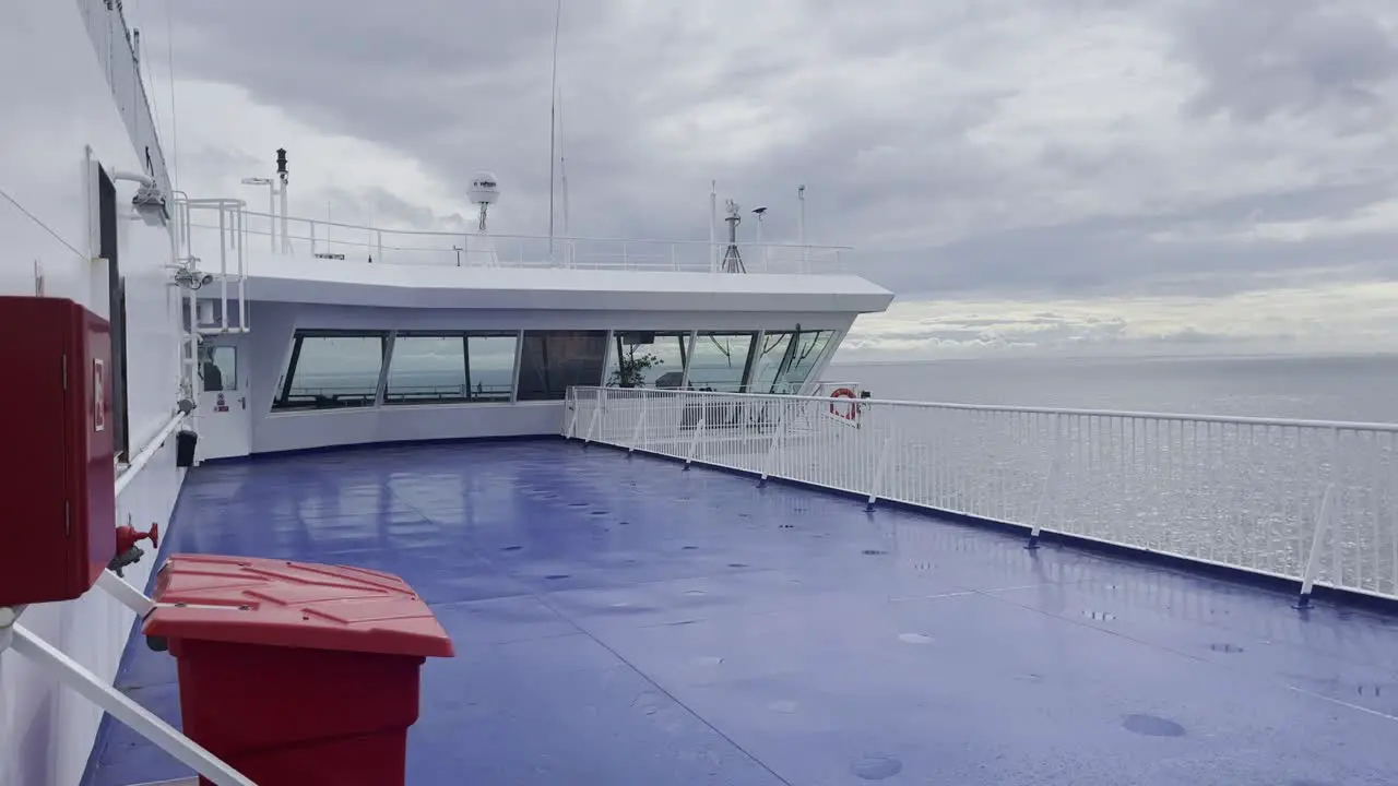 Control bridge from the captain of a ferry on the way to Germany with an empty blue outside deck in bad weather