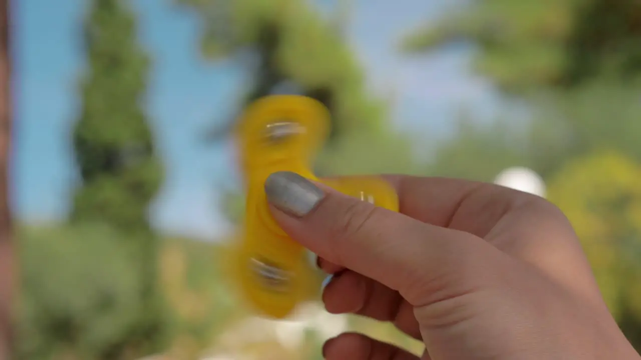 Woman having fun with fidget spinner outside