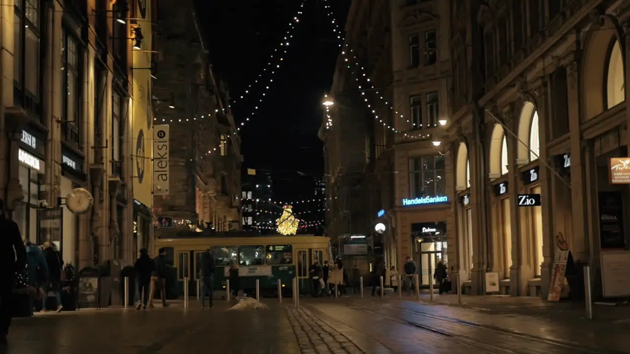 Walking people and passing tram in night street with Christmas lights Helsinki