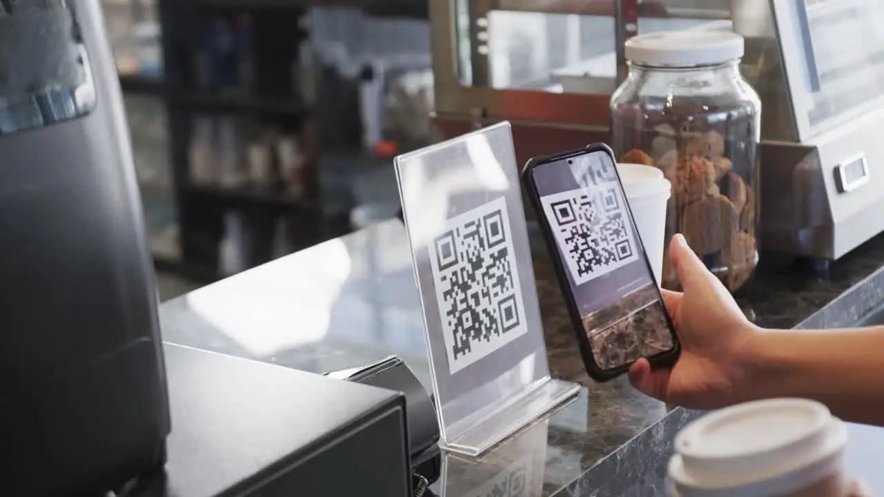 Caucasian customer scanning qr code with smartphone in bakery in slow motion