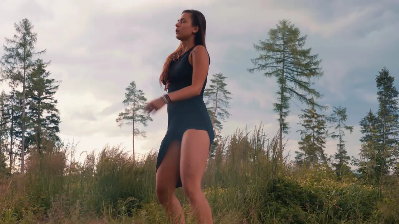 Young woman dances with freedom outdoors in nature medium shot