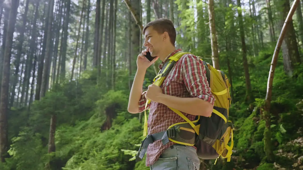 A Person Uses A Smartphone In A Hike Sits By A Beautiful Forest